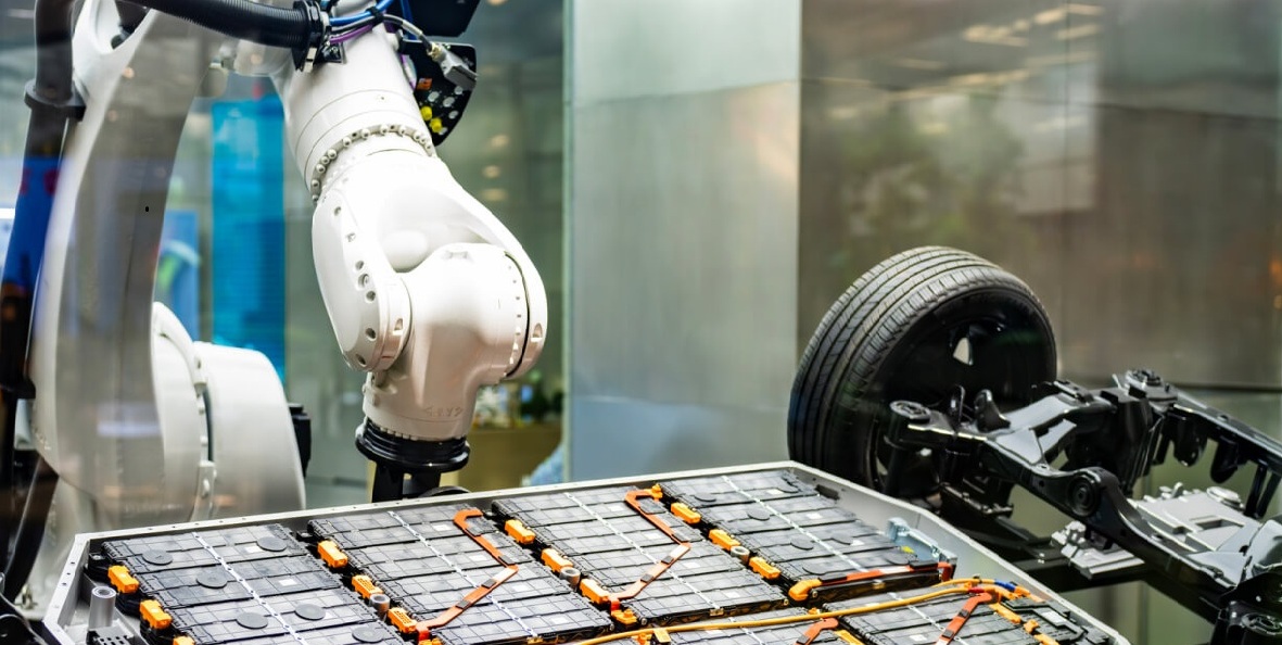 Robotic arm assembling EV battery cells. 