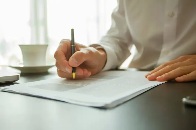 ALL - Generic - Landscape - A closeup of a person signing a document