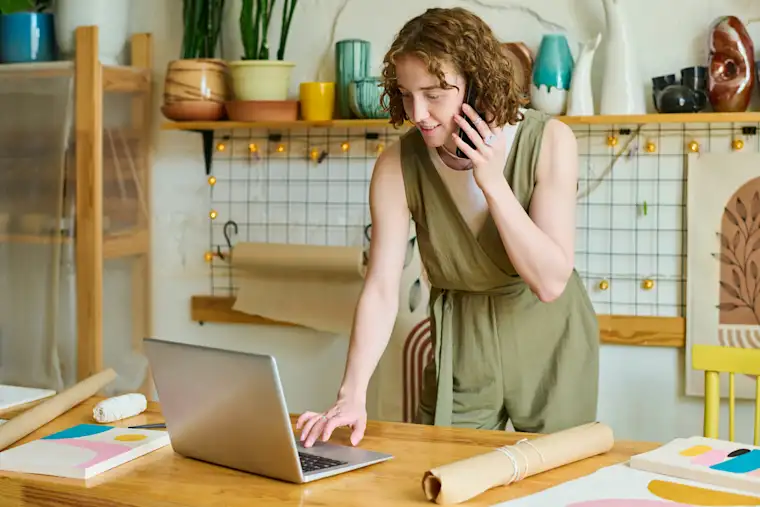 Freelancer young woman on phone and laptop