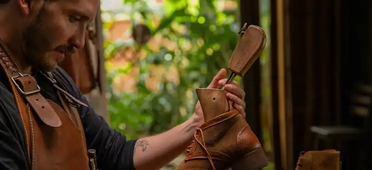 Proximity services-landscape-shoemaker-fr-shoemaker holding leather shoe