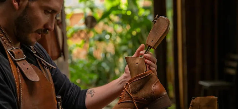 Proximity services-landscape-shoemaker-fr-shoemaker holding leather shoe