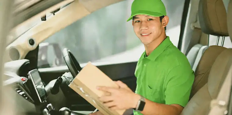 Courirer man sitting with package in a business delivery car