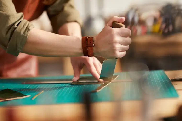 Proximity Services-landscape-shoemaker-fr-cutting leather close up