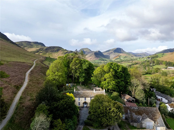 Aerial view of Beatrix Potter cottage for sale in Keswick, Cumbria surrounded by mountainous fells