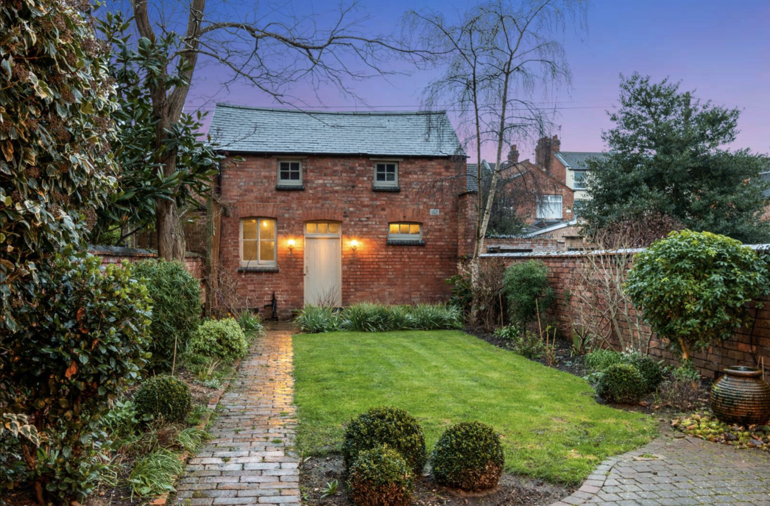 Red brick coach house at the bottom of the garden of a domestic home. Currently being used as a garage but ripe for conversion into a residential annexe