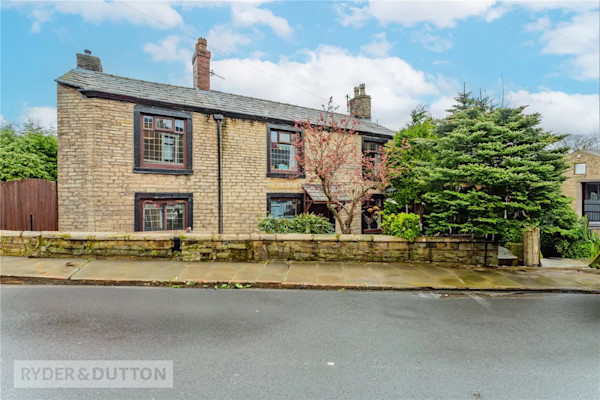 A cottage-style three bedroom detached house in Oldham with brown brick exterior 