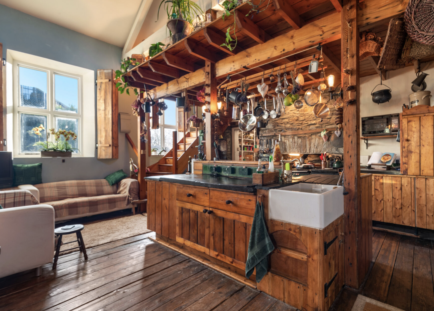 Interior of an old converted schoolhouse with a bespoke wooden kitchen and quirky layout