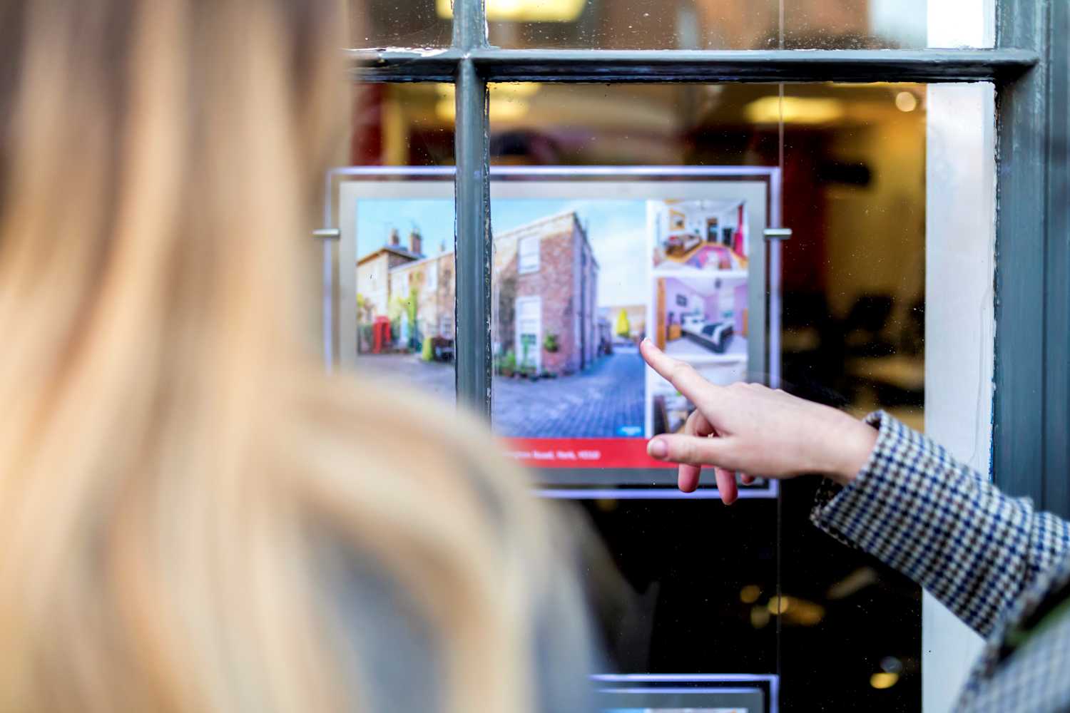A woman looking into an estate agent's window
