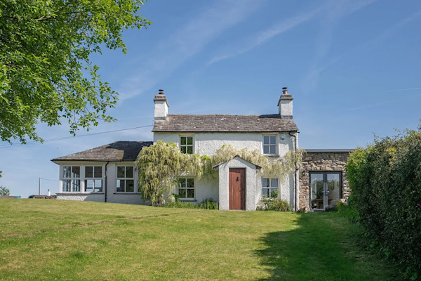 A rural cottage for sale located in Kendal with a large lawn