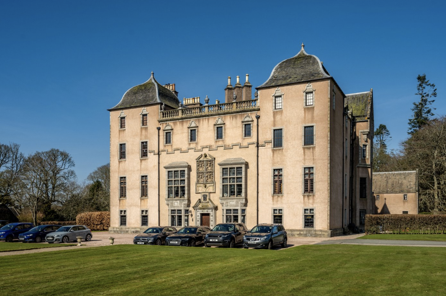 A grand mansion in Scotland with ornate windows and roof turrets