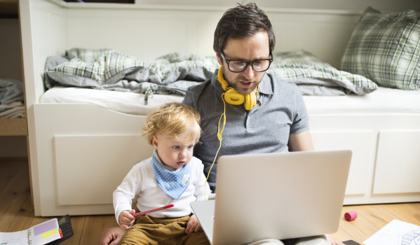 Dad and son at laptop - Getty Images