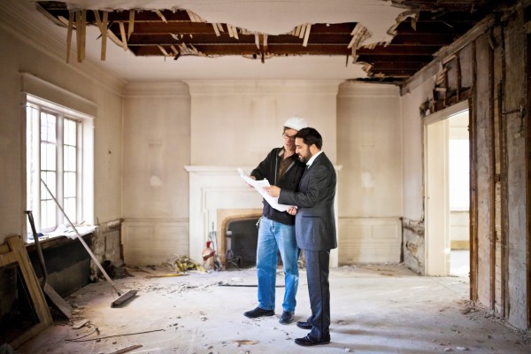 Two adults in a lounge where the ceiling has been pulled down