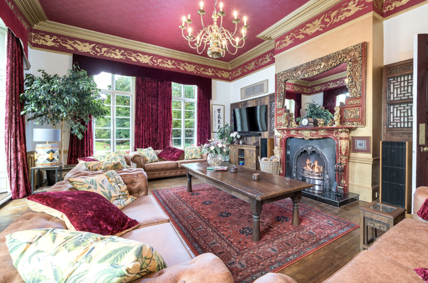 Sumptuous interior of a drawing room, with an open fire and gilded cornicing