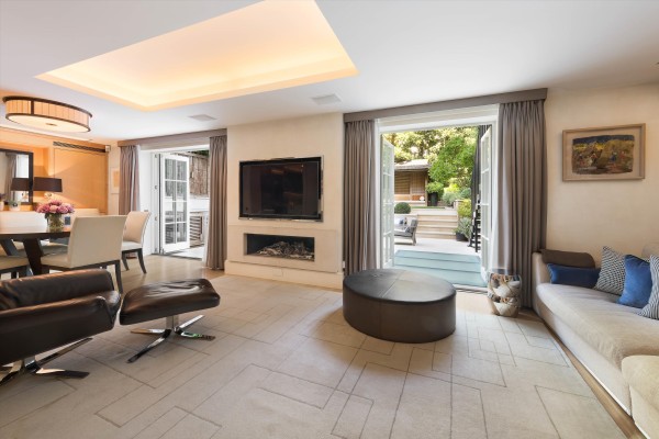 A contemporary and neutral reception room with two sets of French doors leading to the landscaped terrace.