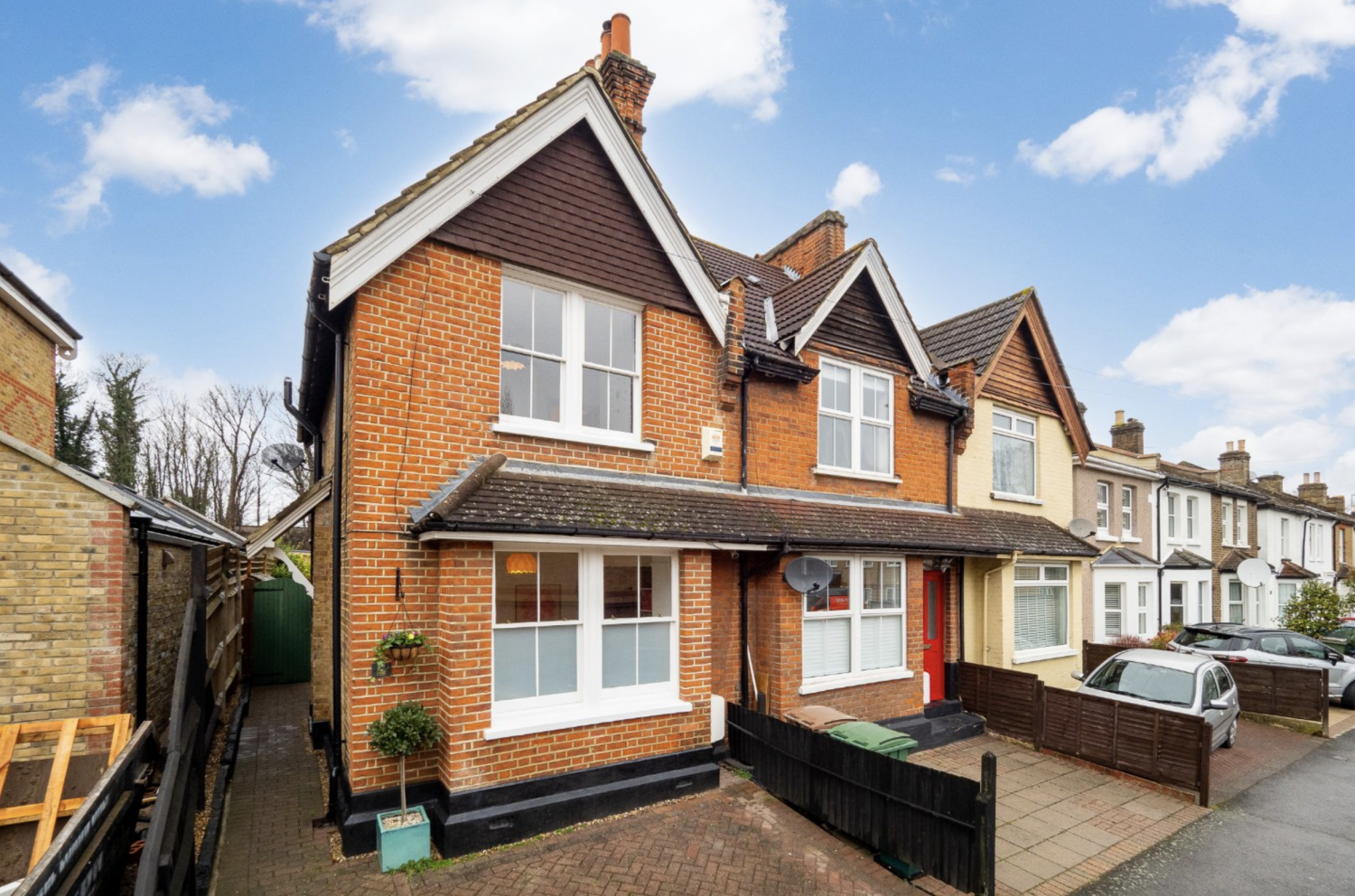Red brick Edwardian semi-detached family home with gabled roof at the front and off-street parking