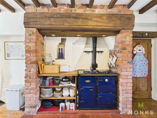 An AGA-style range cooker set within a brick surround