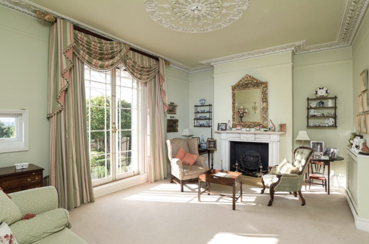 a grand drawing room with ruffled curtains and period furniture to match the original Georgian features