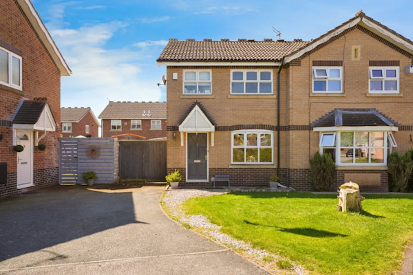 A modern semi-detached house for sale in Knowlsey with a large driveway and front lawn