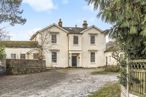 The exterior of a large country house in Wales that was the 5th most viewed property on Zoopla in 2023. A large muddy driveway leads to the imposing cream house.