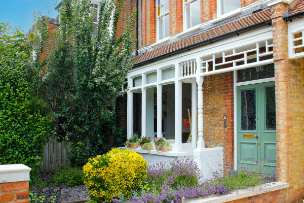 Edwardian three bedroom flat conversion home in Harringay with flowers and a green front door