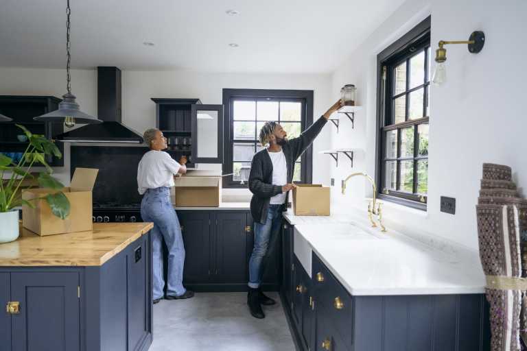 A couple placing items in their brand new kitchen