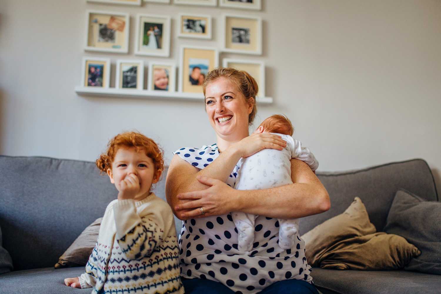 A woman with her children sitting on a sofa in a lounge