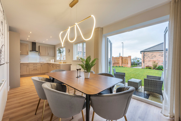 A large and modern kitchen/dining room in light colour scheme with French doors to the garden