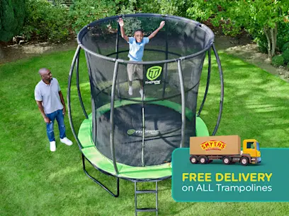 A kid jumping on the 8ft Thorpe Trampoline with Enclosure Net in a green garden.