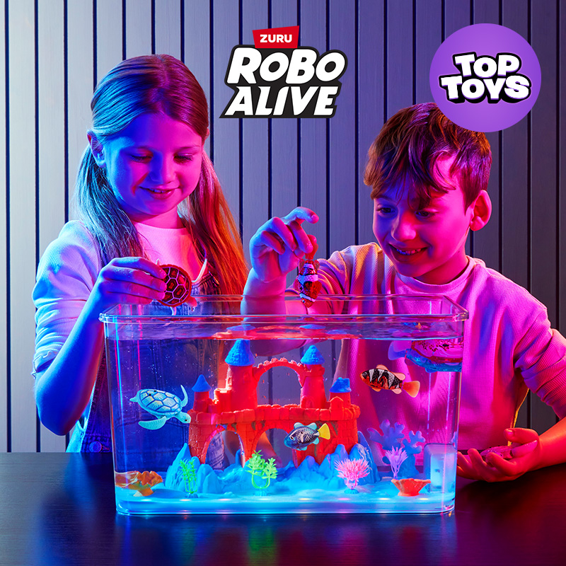 Two kids playing with the Robo Alive ZURU Mega Aquarium Set 17 Piece on a tabletop in a room.