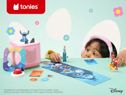 A kid playing with the Tonies box on a green table