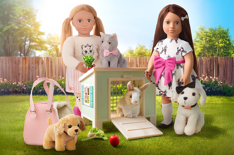 Two Our Generation dolls with their pets in a garden