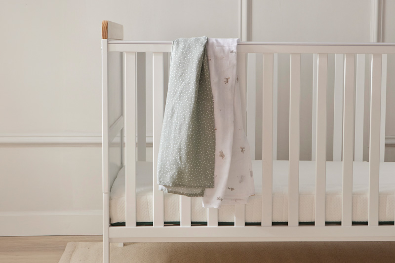 white cot bed with blankets