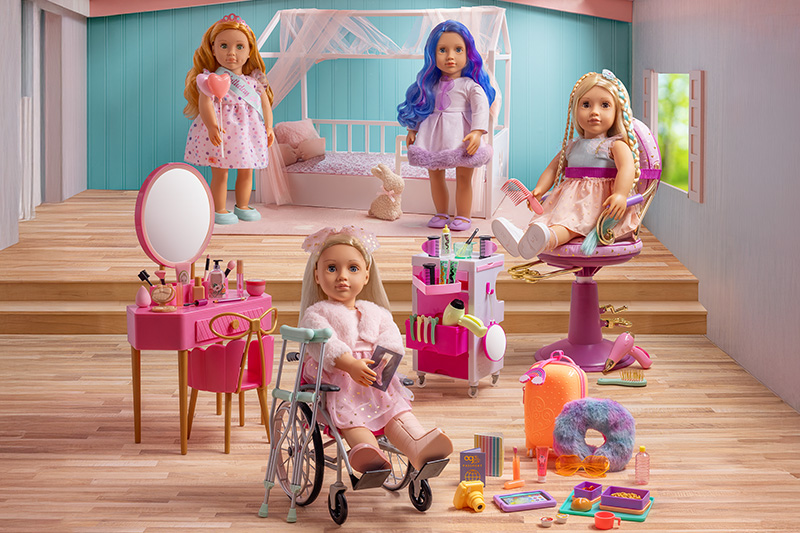 Four Our Generation Dolls and accessories in a room