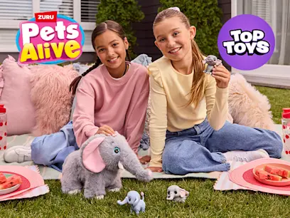 Two girls sitting on a lawn playing with the Pets Alive by ZURU Mommy Elephant and Baby Surprise Set