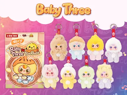 Baby Three promotional image showing a boxed Baby Three Bao Buds set and eight fluffy pastel character keychains in different colors, arranged against a pink and purple background.