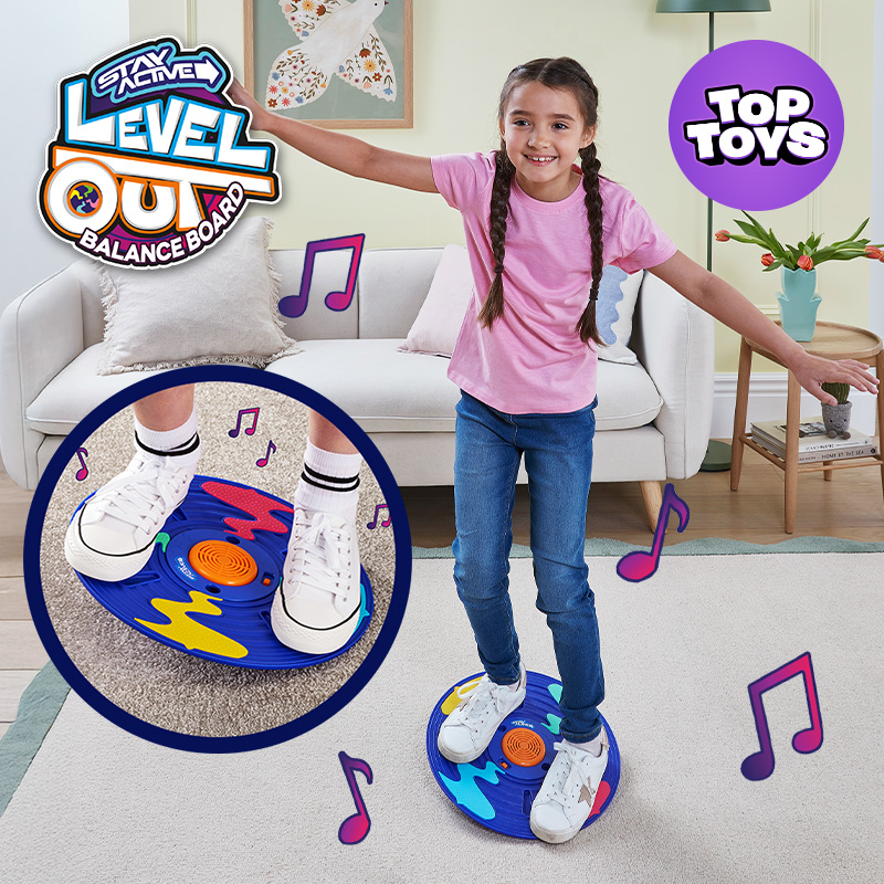 "Stay Active Level Out Balance Board, Top Toys" logo with a girl balancing on a colorful round balance board, arms outstretched, inset close-up of her feet on the board.