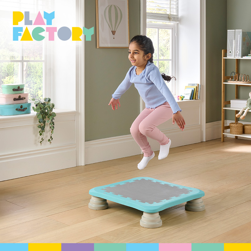 Play Factory promotional image showing a smiling child jumping on a small turquoise indoor trampoline in a bright home, with the colourful Play Factory logo in the upper-left corner.