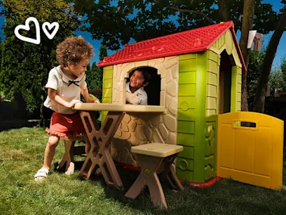 Two kids playing in the Deluxe Playhouse with Table and Chairs in a garden.