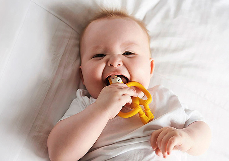 happy baby with monkey stick teether