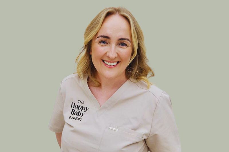 A lady standing against a beige background