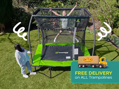 A kid jumping on the 8x6ft Thorpe Sports Rectangular Trampoline with Net in a green garden.