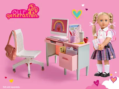 Our Generation school-themed doll playset featuring a pink and mint desk, computer, stationery, chair and school accessories, alongside a blonde doll in a school uniform with a pink backpack. Doll sold separately.