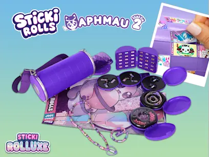 Sticki Rolls x Aphmau Sticki Rolluxe set displayed with a purple cylindrical bag, jewellery, hair accessories and small purple cases. An inset shows a hand opening the set, with the Sticki Rolls and Aphmau logos above.