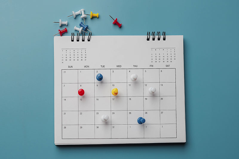 A calendar planner on a blue wall
