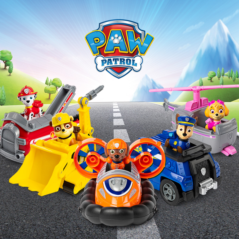 PAW Patrol logo above five pups in colorful rescue vehicles on a road: Marshall in a fire truck, Rubble in a bulldozer, Skye in a helicopter, Chase in a police vehicle, and Zuma in an orange hovercraft.