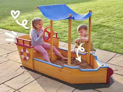 Wooden Boat-Shaped Sandbox on the outdoor background 
