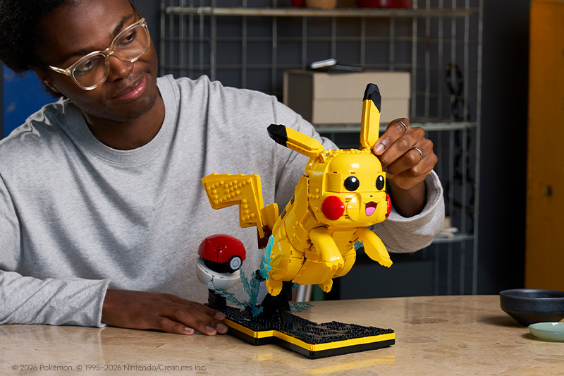 The LEGO Pokemon 72152 Pikachu and Poké Ball Set Adults on a table in a living room.