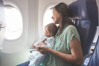 A mum travelling with her baby and sitting on an aeroplane