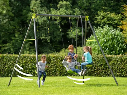 A kids playing on the Apatou Metal Swing Set with 3 Seat Units in a bright garden.