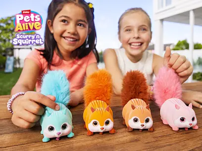 Two kids playing with the Pets Alive by ZURU Scurry'n Squirrel Interactive Assortment on a table in their garden.